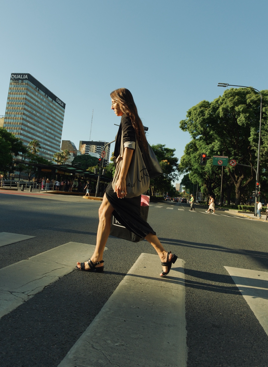A woman crosses a sunlit street in Buenos Aires