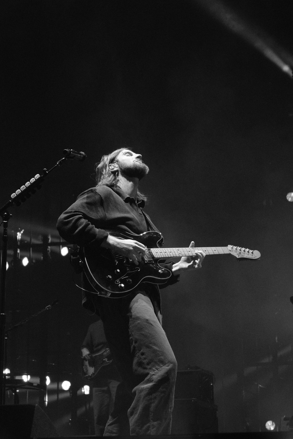 A guitarist looks upward while playing electric guitar